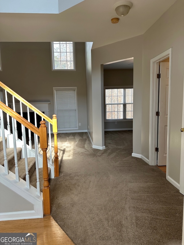 entrance foyer featuring dark carpet