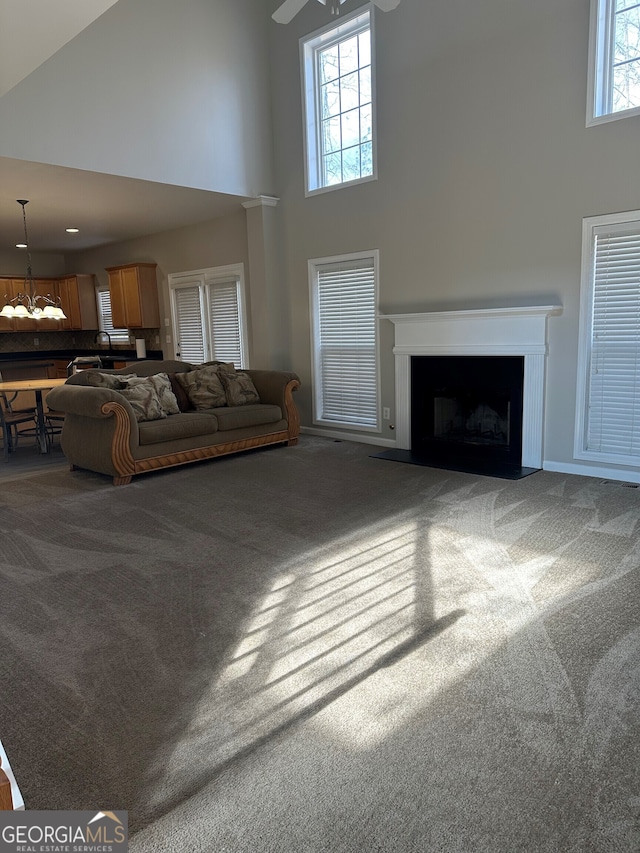 living room with a high ceiling and carpet floors