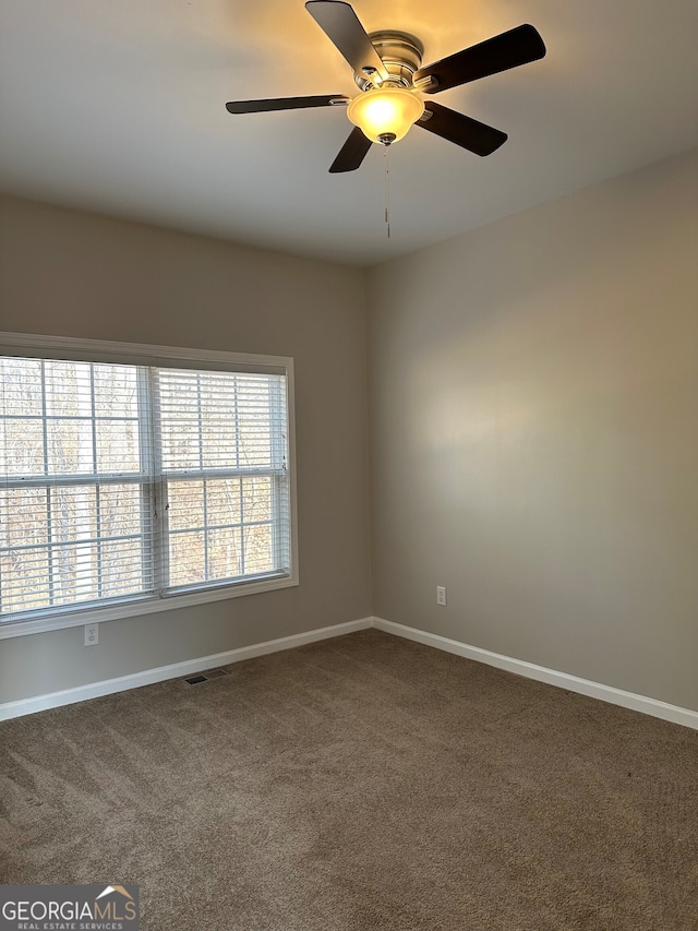 carpeted spare room with ceiling fan