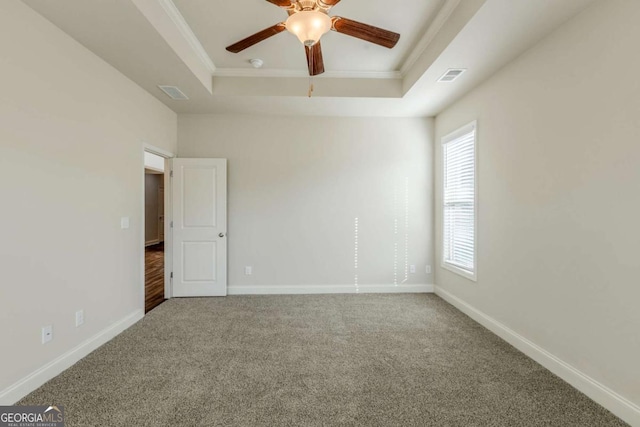 spare room featuring carpet floors, ornamental molding, a raised ceiling, and ceiling fan