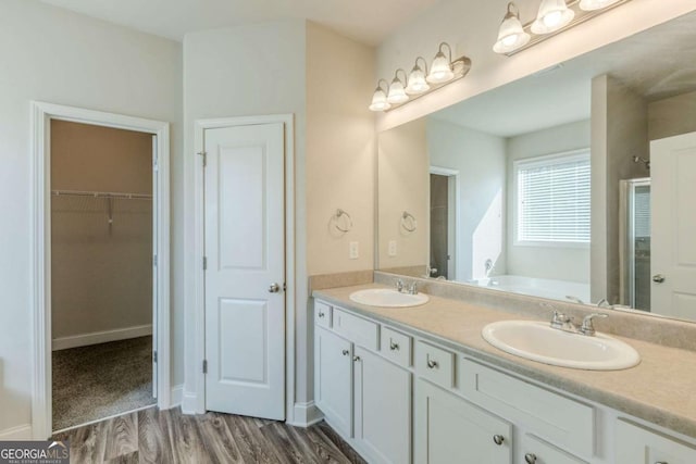 bathroom with wood-type flooring, a bathing tub, and vanity