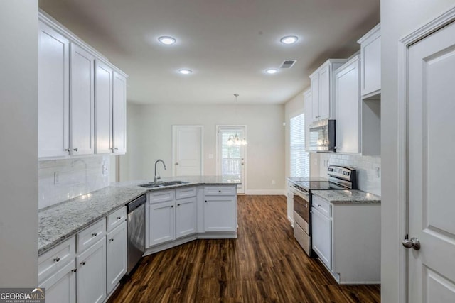 kitchen with sink, white cabinetry, appliances with stainless steel finishes, kitchen peninsula, and pendant lighting