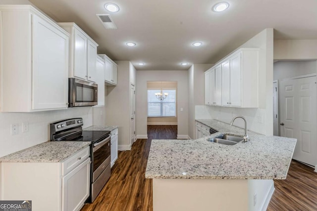 kitchen with sink, white cabinetry, stainless steel appliances, dark hardwood / wood-style floors, and kitchen peninsula