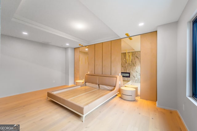 bedroom featuring a fireplace and light wood-type flooring