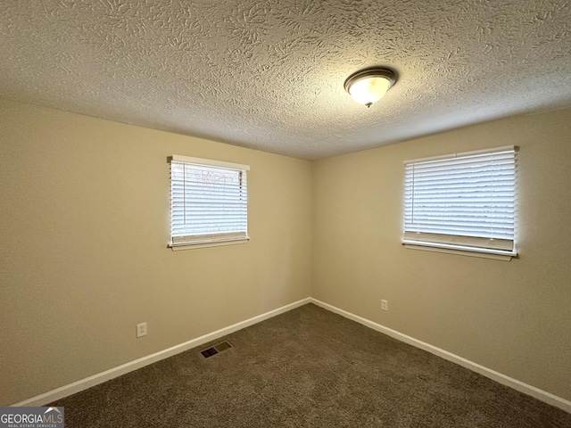 carpeted spare room featuring a textured ceiling