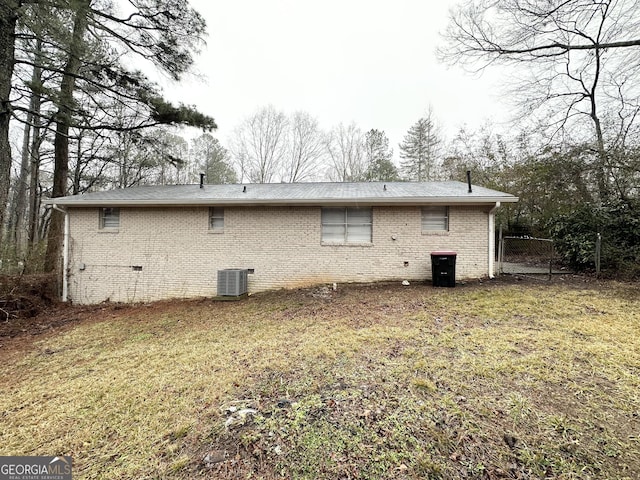 back of house featuring a yard and central air condition unit