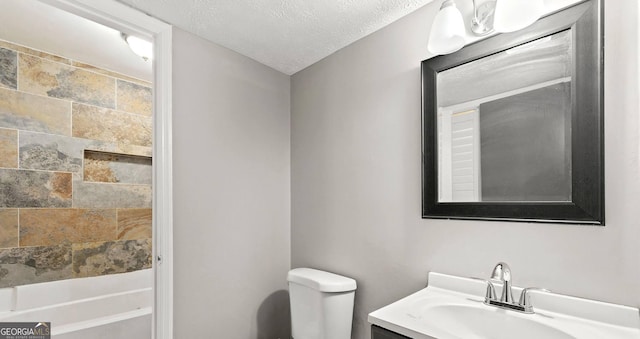 bathroom with vanity, a textured ceiling, and toilet