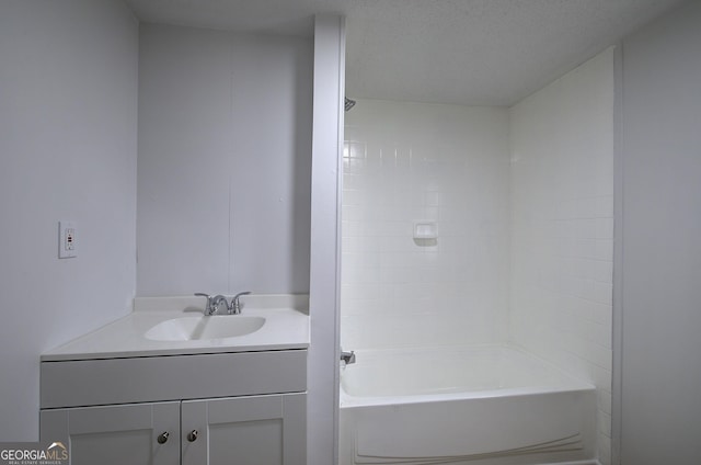 bathroom featuring shower / tub combination, vanity, and a textured ceiling