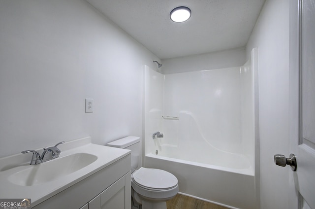 full bathroom featuring hardwood / wood-style floors, shower / bathing tub combination, vanity, toilet, and a textured ceiling