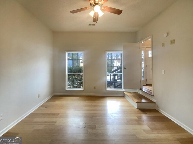 empty room with ceiling fan and light wood-type flooring