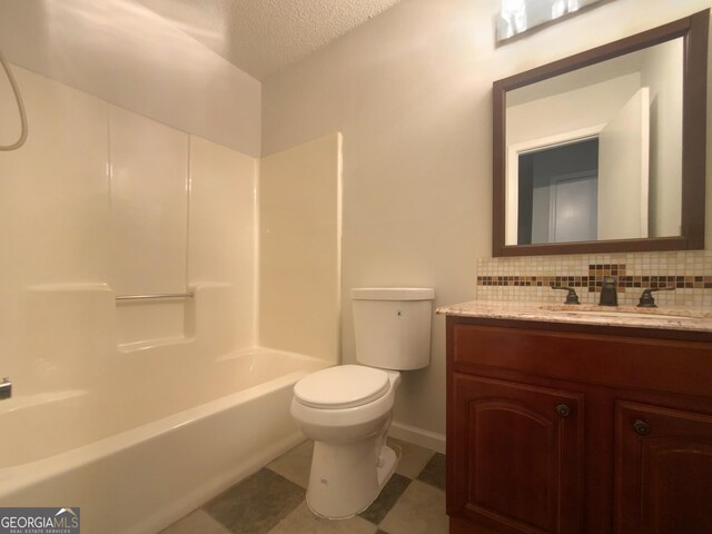 full bathroom with decorative backsplash, vanity, toilet, tub / shower combination, and a textured ceiling