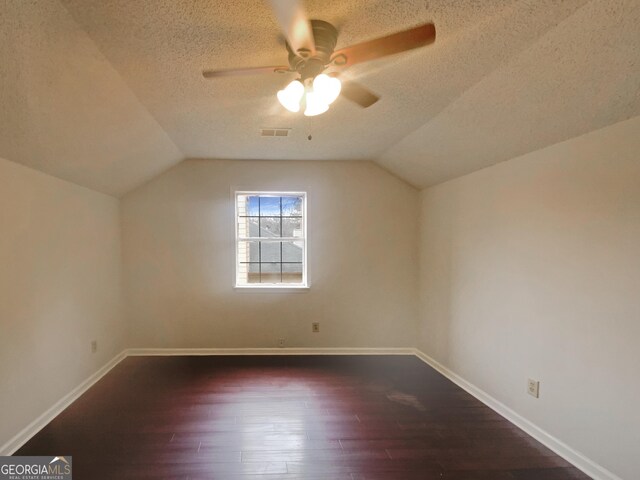 bonus room with vaulted ceiling, dark hardwood / wood-style floors, ceiling fan, and a textured ceiling