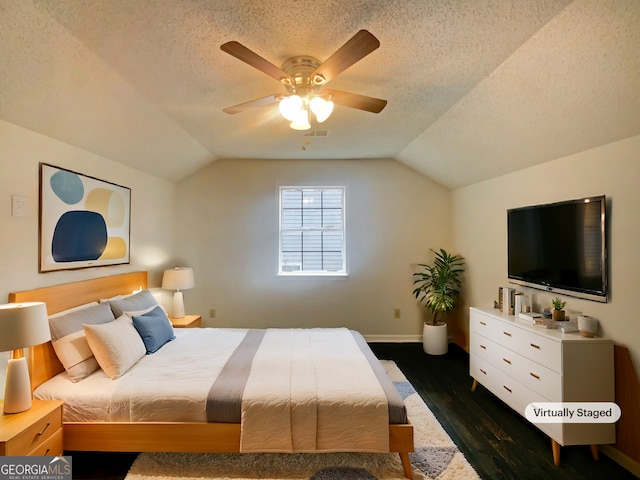 bedroom with lofted ceiling, dark hardwood / wood-style floors, and a textured ceiling