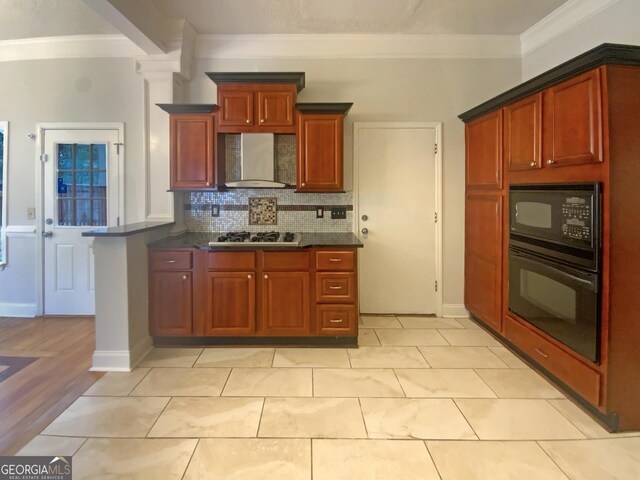 kitchen with wall chimney range hood, light tile patterned floors, tasteful backsplash, ornamental molding, and black appliances