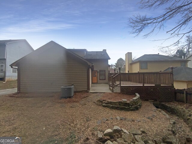 back of house with cooling unit and a wooden deck