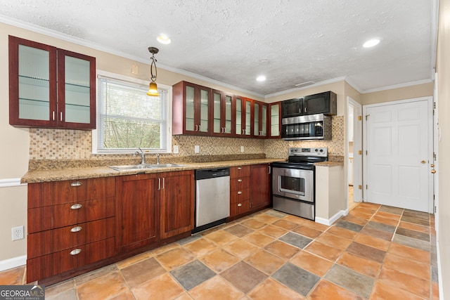 kitchen featuring appliances with stainless steel finishes, decorative light fixtures, tasteful backsplash, sink, and light stone counters