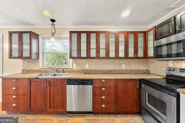 kitchen featuring pendant lighting, sink, stainless steel appliances, and light stone countertops