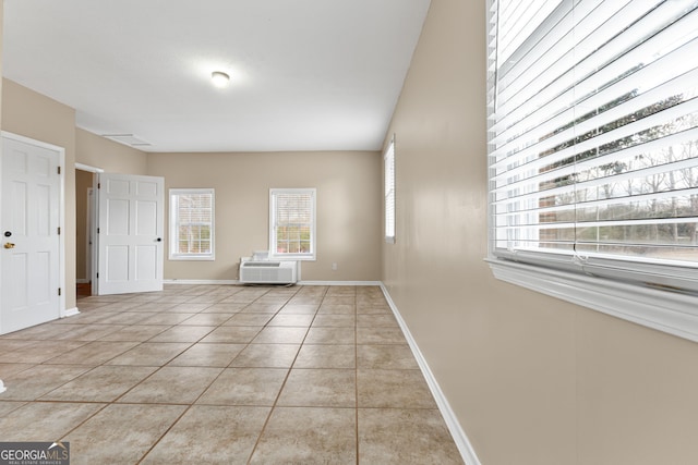 tiled empty room featuring an AC wall unit