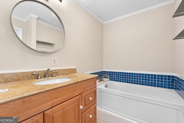 bathroom with ornamental molding, a washtub, vanity, and a textured ceiling