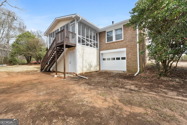 back of house with a garage and a sunroom