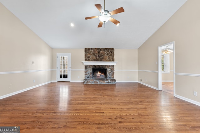 unfurnished living room featuring dark wood-type flooring, ceiling fan, a fireplace, and vaulted ceiling