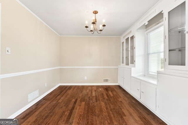 unfurnished dining area with ornamental molding, dark hardwood / wood-style floors, and a chandelier