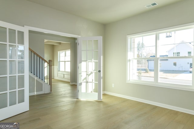 interior space featuring baseboards, stairs, visible vents, and wood finished floors