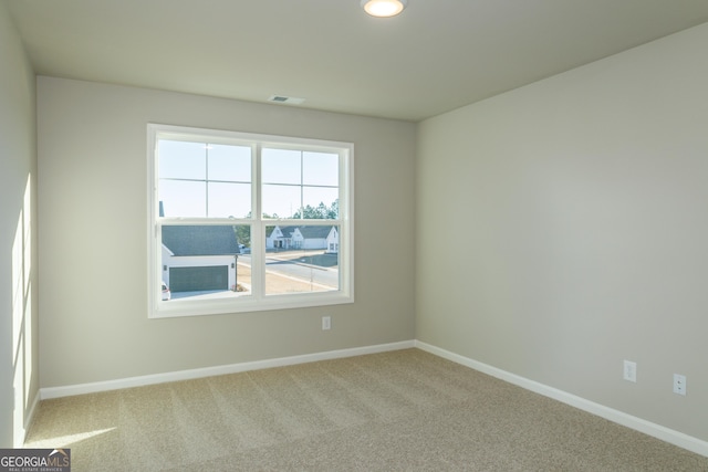 spare room with visible vents, baseboards, and carpet flooring