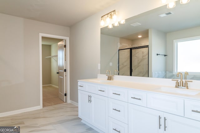 full bath featuring visible vents, a sink, a shower stall, and a spacious closet