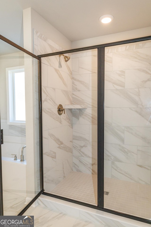 full bathroom featuring marble finish floor and a shower stall