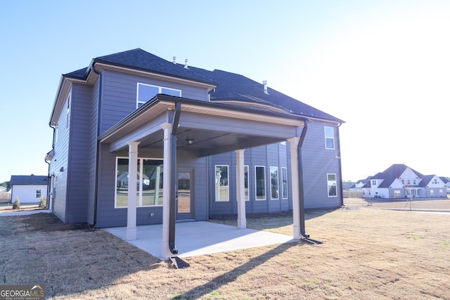 back of house with a patio and a shingled roof