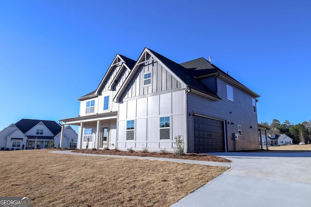 modern farmhouse featuring board and batten siding, concrete driveway, a porch, and a garage