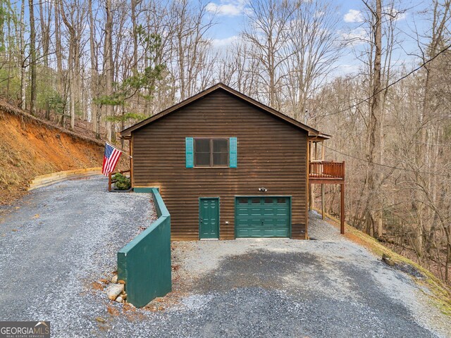 property exterior at dusk with a garage and a deck