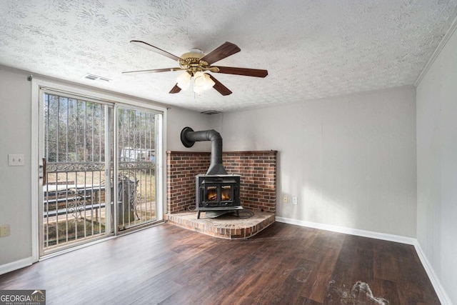 living room featuring hardwood / wood-style floors, a textured ceiling, ceiling fan, and a wood stove