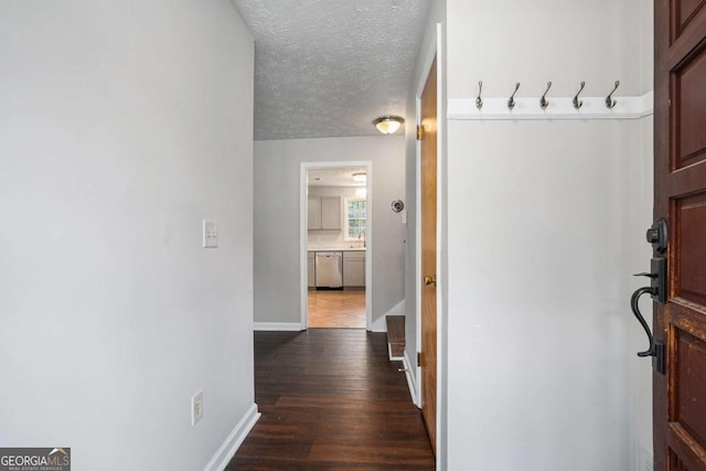 hall with hardwood / wood-style flooring and a textured ceiling