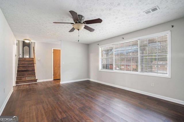 spare room with dark wood-type flooring, a textured ceiling, and ceiling fan