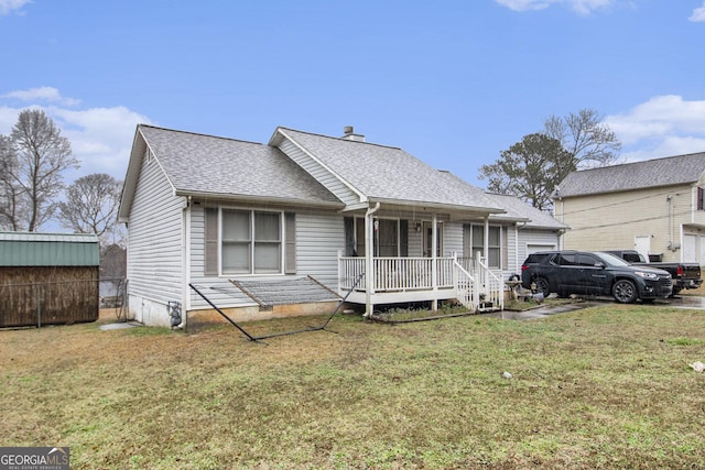 view of front of home with a front yard, covered porch, and a shingled roof