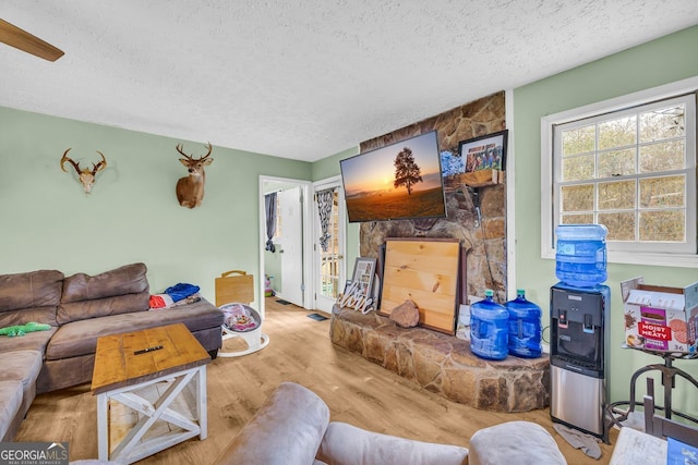 living room with a textured ceiling and light hardwood / wood-style floors