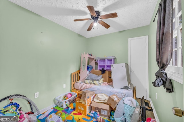 bedroom featuring ceiling fan and a textured ceiling