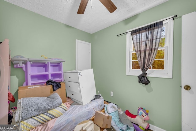 bedroom with ceiling fan and a textured ceiling