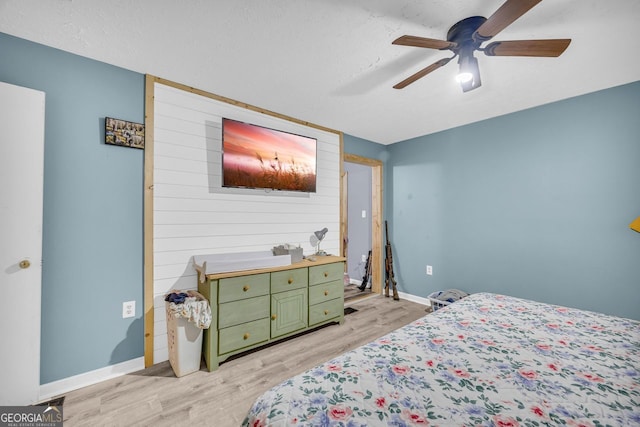 bedroom featuring ceiling fan, a textured ceiling, and light hardwood / wood-style flooring