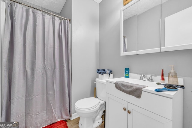 bathroom with vanity, a textured ceiling, and toilet