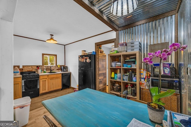 kitchen featuring sink, light brown cabinets, ornamental molding, light hardwood / wood-style floors, and black appliances