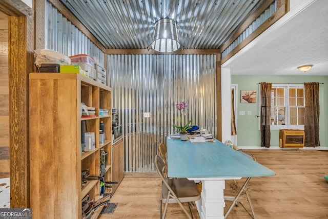 dining room with heating unit and light hardwood / wood-style flooring