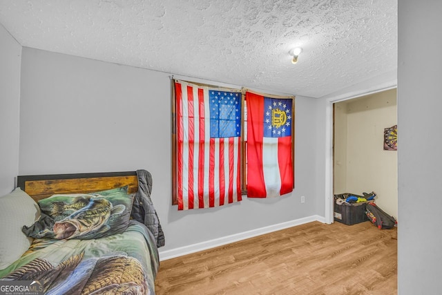 bedroom with wood-type flooring and a textured ceiling