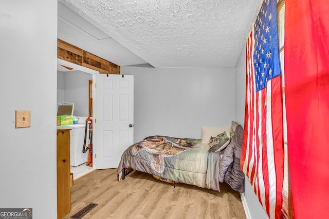 bedroom with wood-type flooring and a textured ceiling