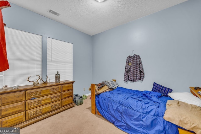 carpeted bedroom featuring a textured ceiling