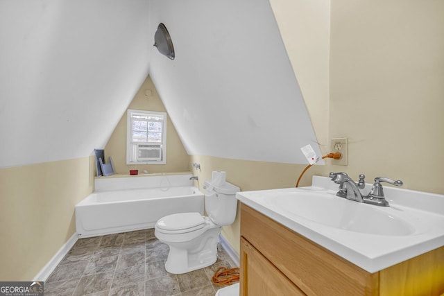 bathroom with a bathing tub, lofted ceiling, vanity, and toilet