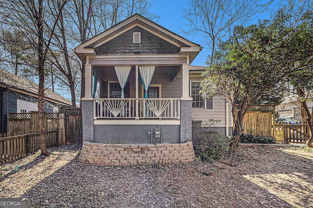 view of front of property with a porch and fence