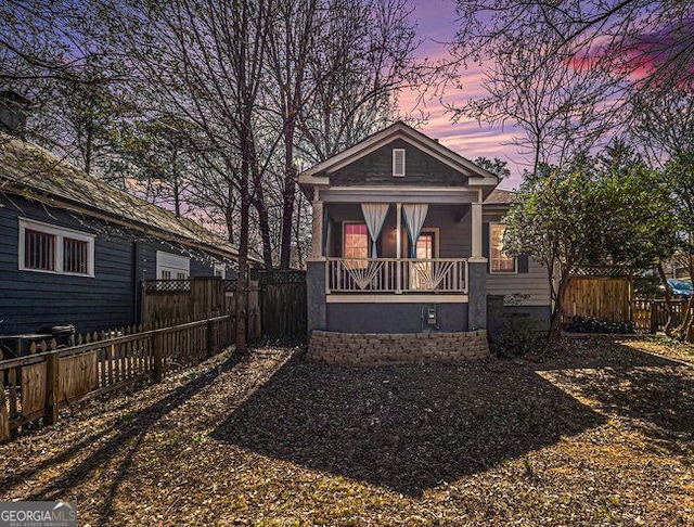 view of front facade featuring a porch and fence